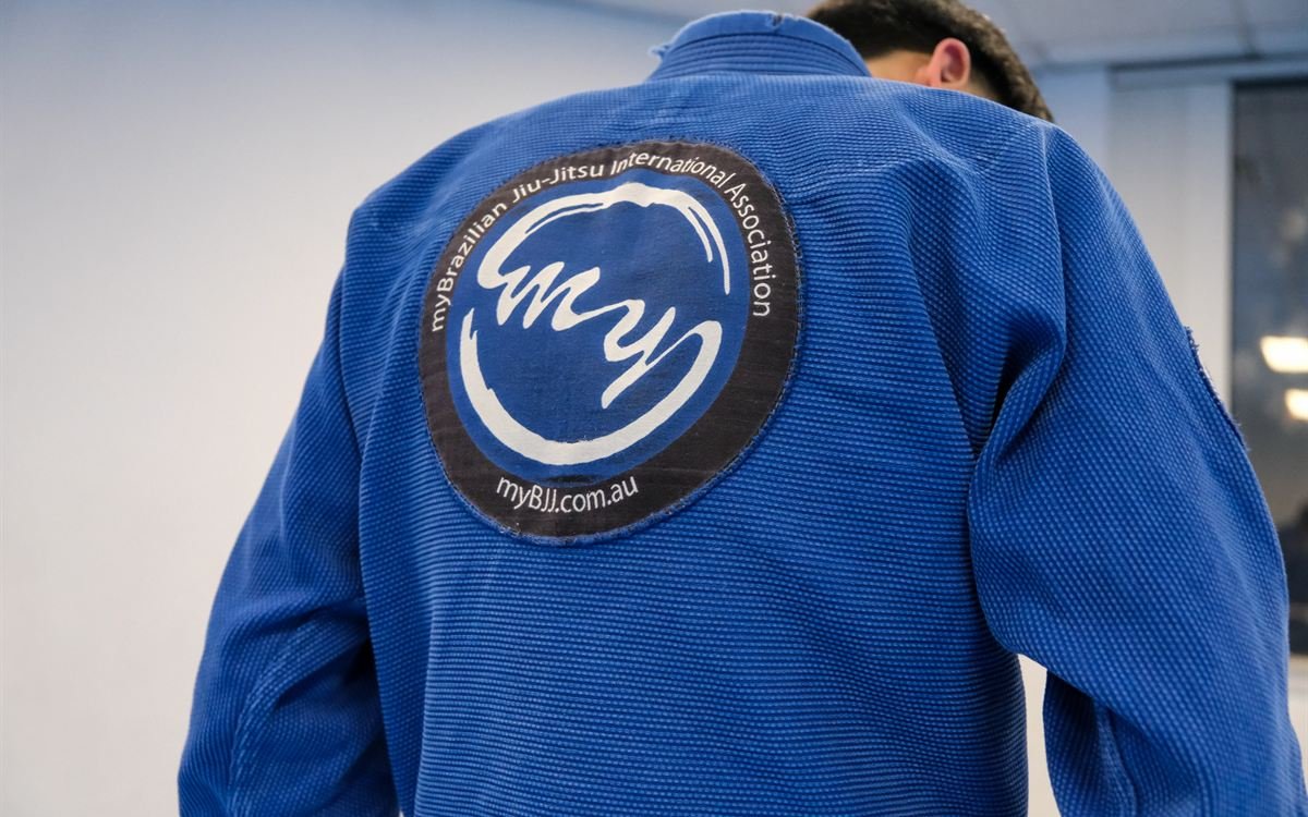 The team patch on the back of a blue gi