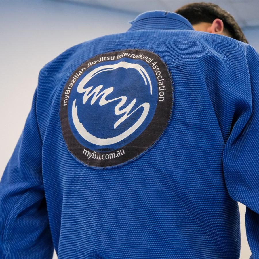 The myBJJ team patch on the back of a blue gi