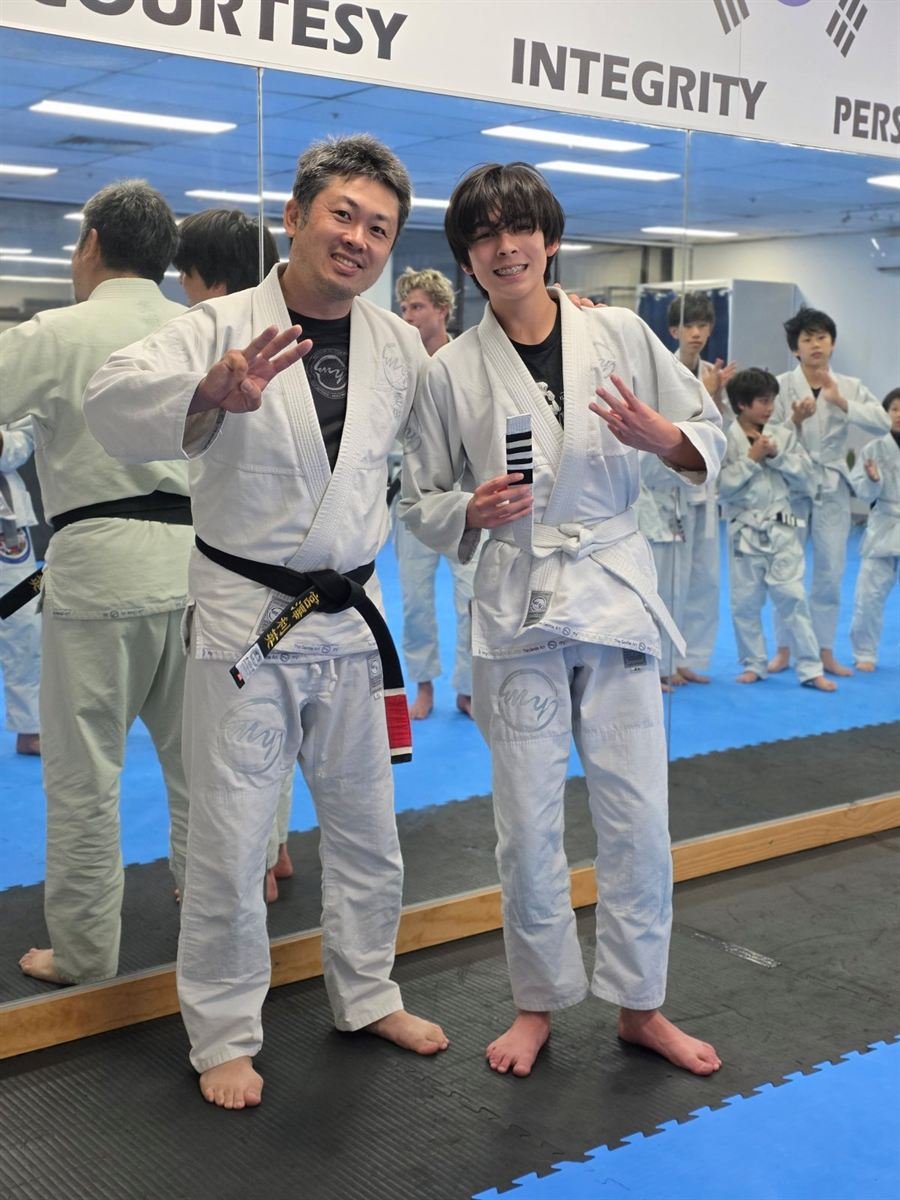 Toshi and a student throwing peace signs on grading night