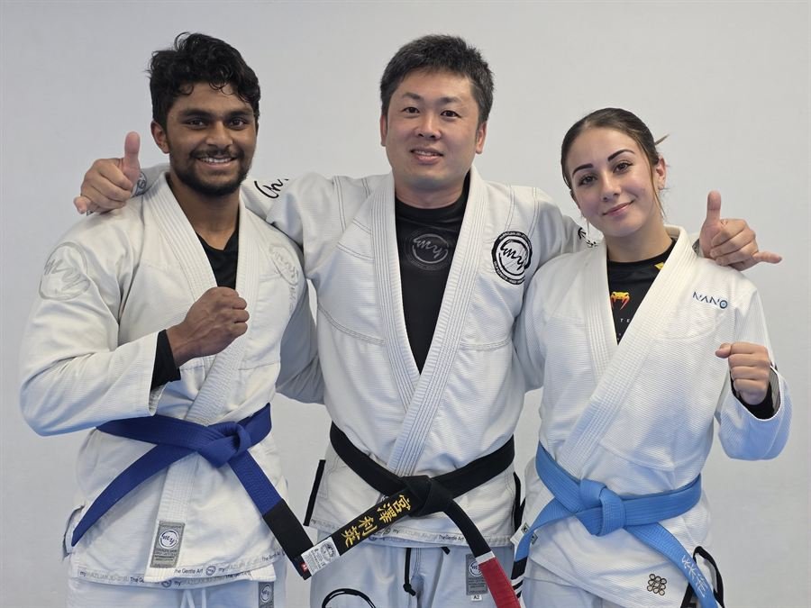Three myBJJ Miyazawa members in gis with their instructor after training